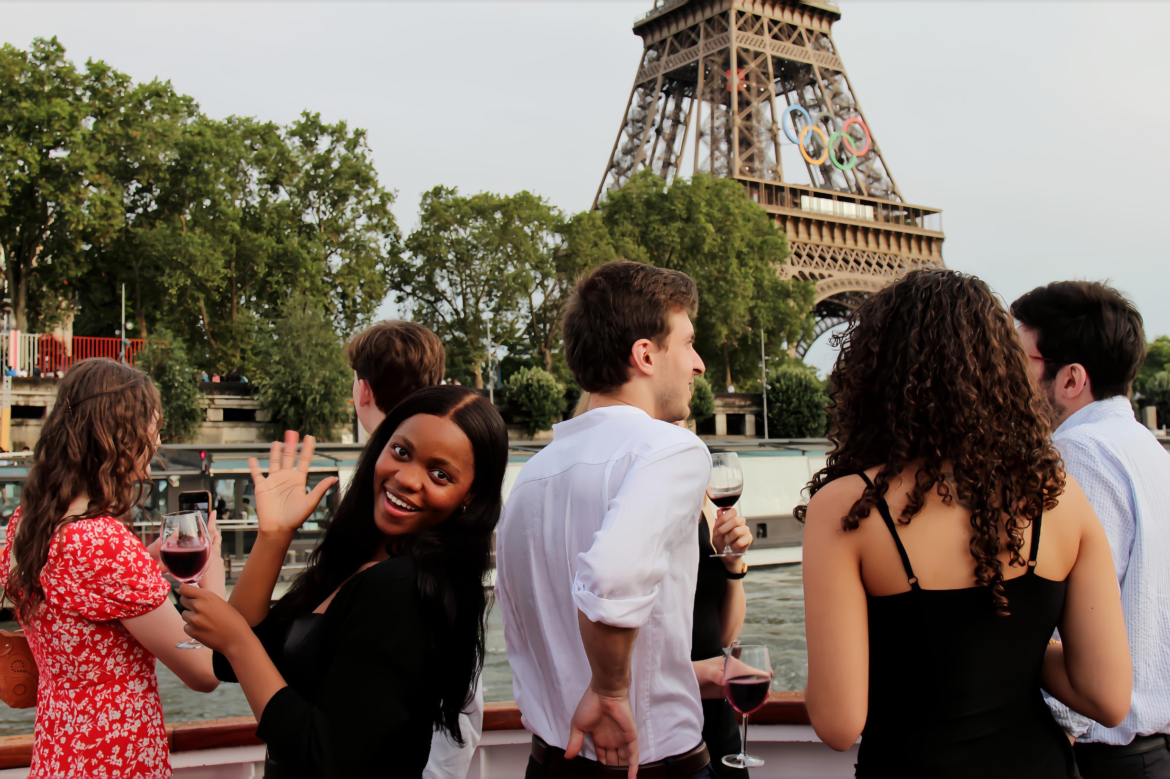 Group of people on a boat with the Eiffel Tower in the background